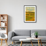 Living room with a gray sofa, wooden coffee table, and framed poster of Erin Hills Golf Course in Wisconsin on the wall.